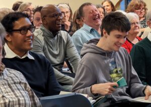 Photo of chorus members laughing at rehearsal